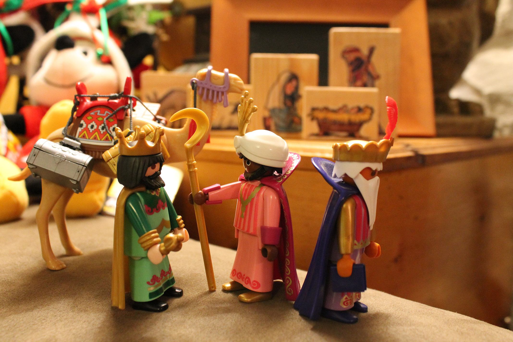 Three wisemen and a wooden manger behind them.