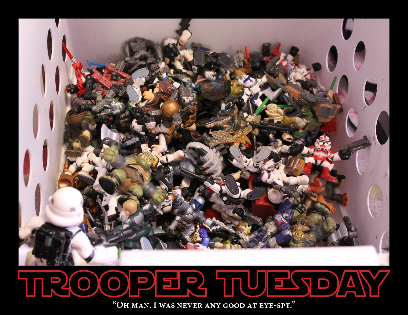 A Stormtrooper stand over a bin full of toys Star Wars figures.